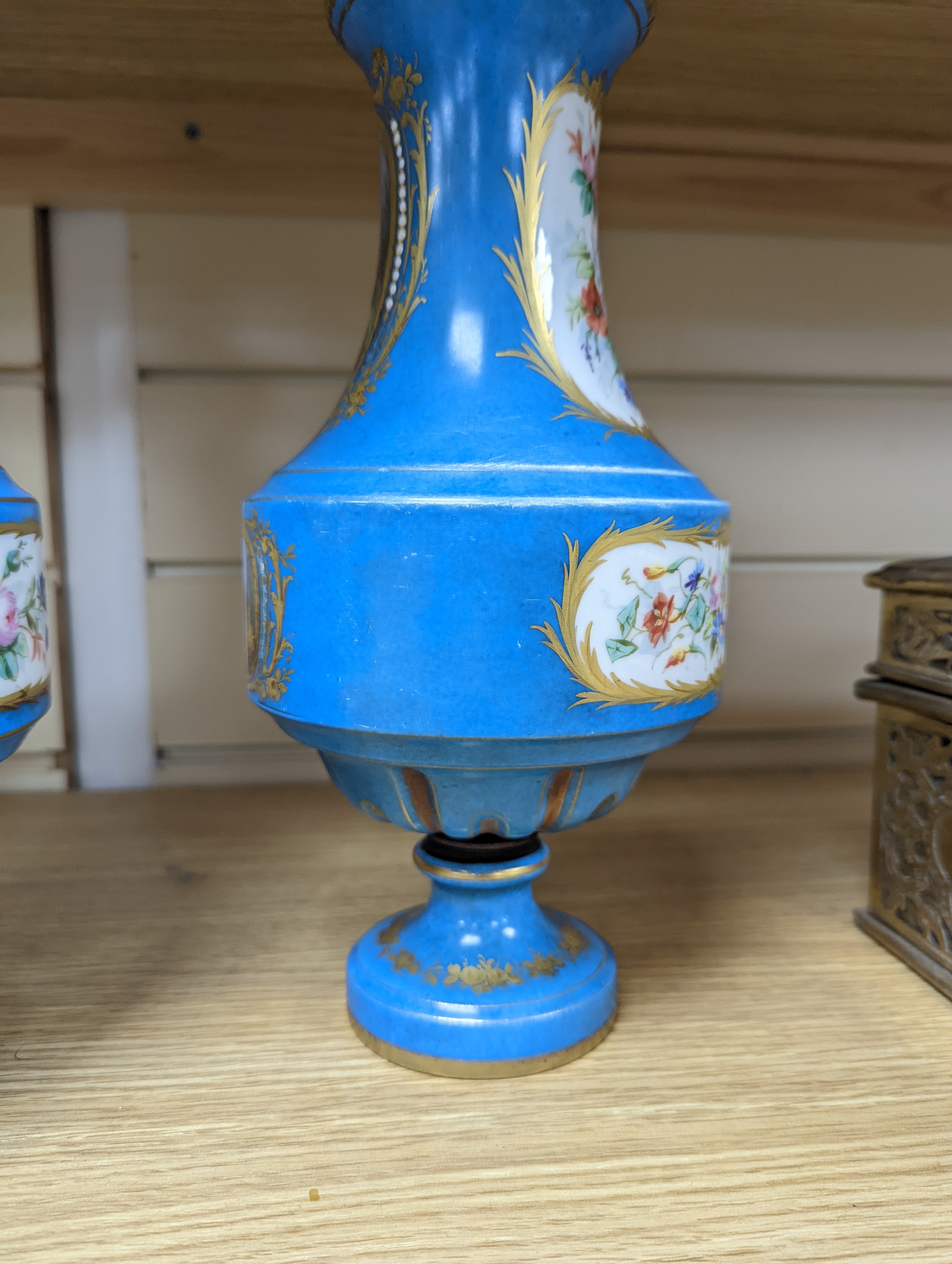 A pair of Sevres style porcelain bleu celeste ground vases and covers, 34cm